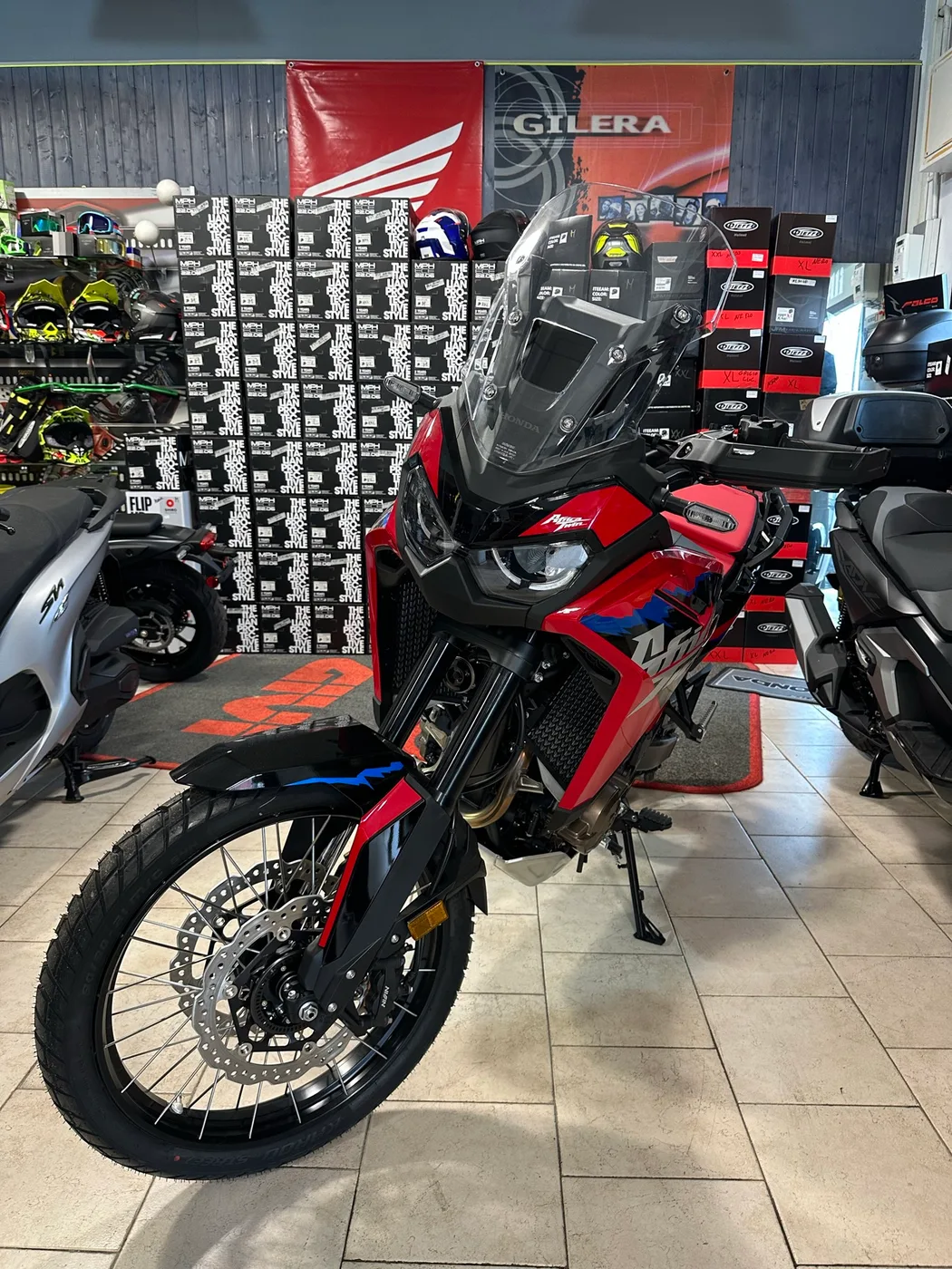 Moto rossa e nera con ruote a raggi nel negozio.