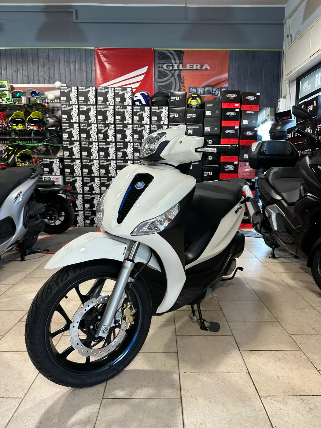 Scooter bianco fotografato di tre quarti nel negozio MotoMoschitto.