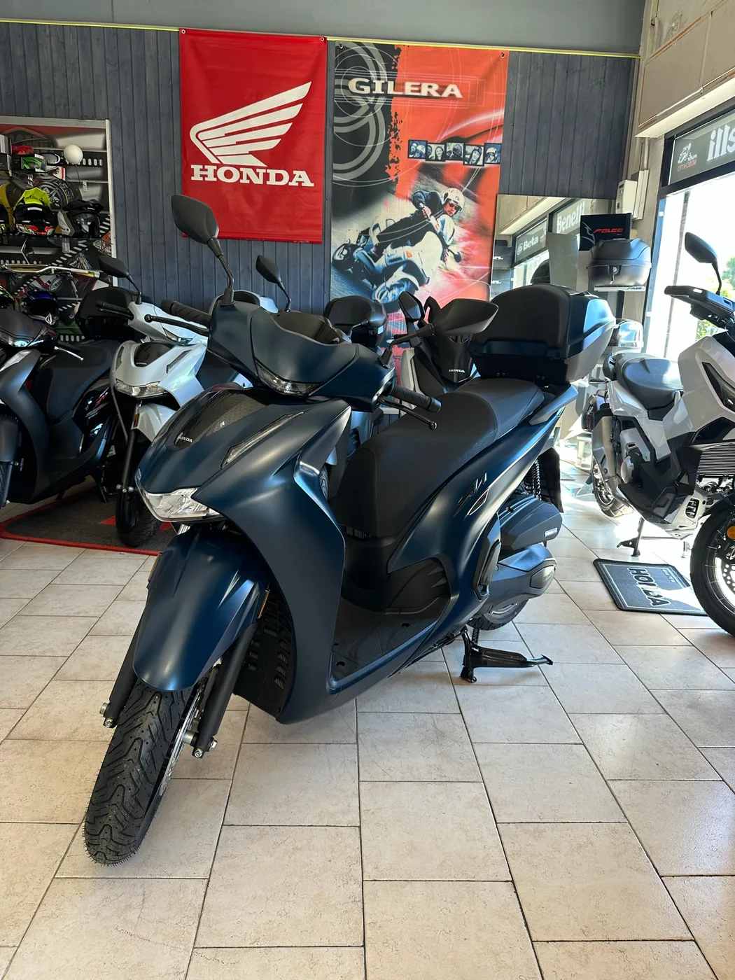 Scooter blu con bauletto nel negozio MotoMoschitto.